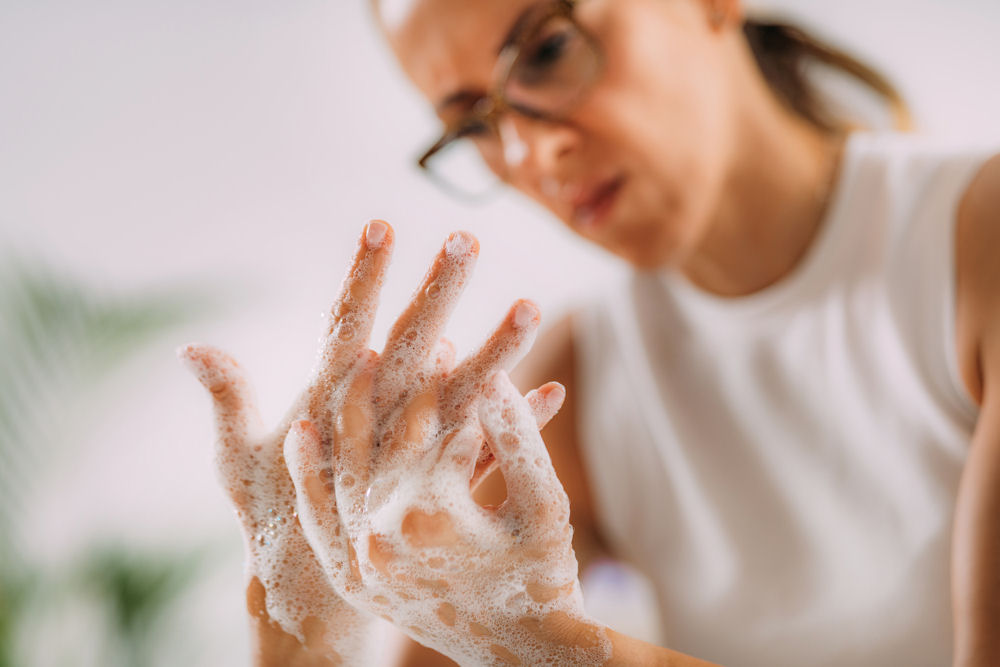 woman with ocd and addiction washing her hands