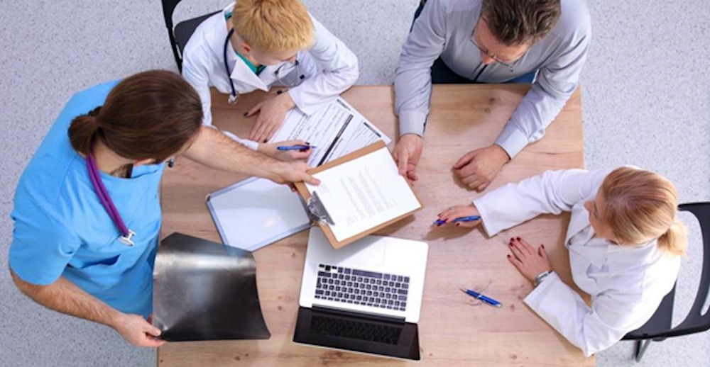 A team of doctors discussing patient cases at a conference table