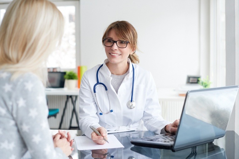 A female doctor attentively conversing with a patient, providing medical care and support.