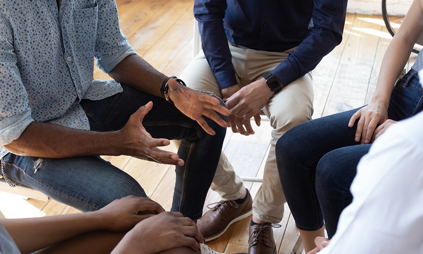 A diverse group of individuals engaged in a lively conversation while seated around a table.